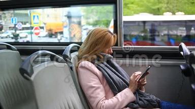 年轻漂亮的女士乘旅游观光车旅行，带着智能手机